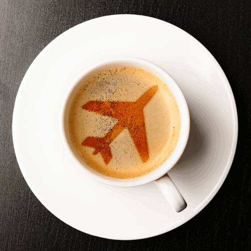The outline of an airplane is depicted in the creamy foam of a coffee cup.