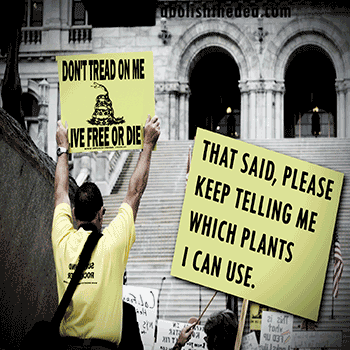 A man in a yellow shirt is holding a sign that says "Don't Tread on Me" and "That Said, Please Keep Telling Me Which Plants I Can Use."