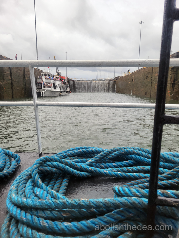 Water flowing over locks in Panama Canal, seen from the bow of a tourist boat.