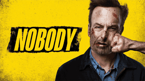 Poster for the movie Nobody starring Bob Odenkirk as Hutch Mansell.  Image depicts a portrait shot of Hutch being blindsided by a slug to the jaw from an off-screen assailant.